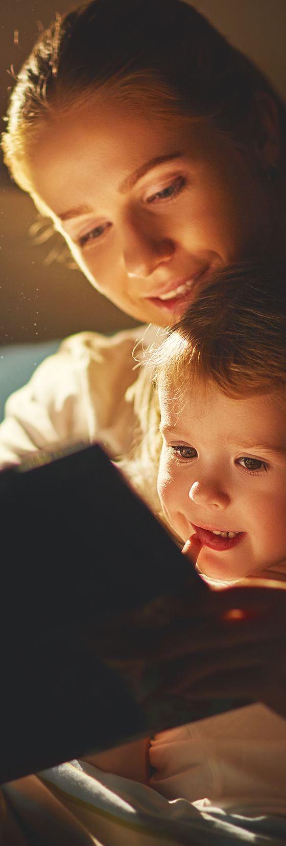 A parent and child reading together by warm, low-glare LED light